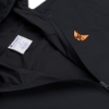 Close-up of the Ditch Witch Packable Jacket showing the embroidered orange moon logo, zipper detail, and Champion branding inside the jacket.