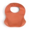 Back view of the orange Dig In Silicone Bib showing the smooth silicone surface and adjustable neck closure.
